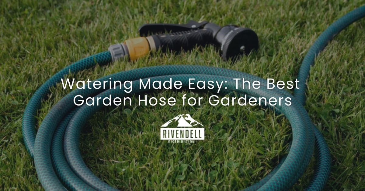 Green garden hose coiled on grass with nozzle.