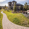 Curving stone pathway beside a luxury home, showcasing landscaping design.
