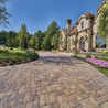 Antiqued pavers create a charming driveway leading to a luxurious home.
