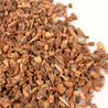Close-up of reddish-brown mini bark nuggets against a white background.
