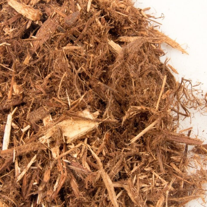 Brown cedar mulch pile, showing wood texture and fiber.
