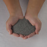 Hands cupping gray MicroClover seed for lush lawns.
