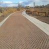 Brown permeable pavement path with textured surface, next to a concrete walkway.
