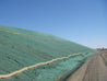 Hydromulch erosion control on a sloped terrain, stabilized with coir logs.
