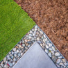 Galvanized steel edging installed between artificial turf, gravel, and mulch.
