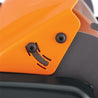 Close-up of reel mower's orange plastic housing and gray metal blade, showing detail.
